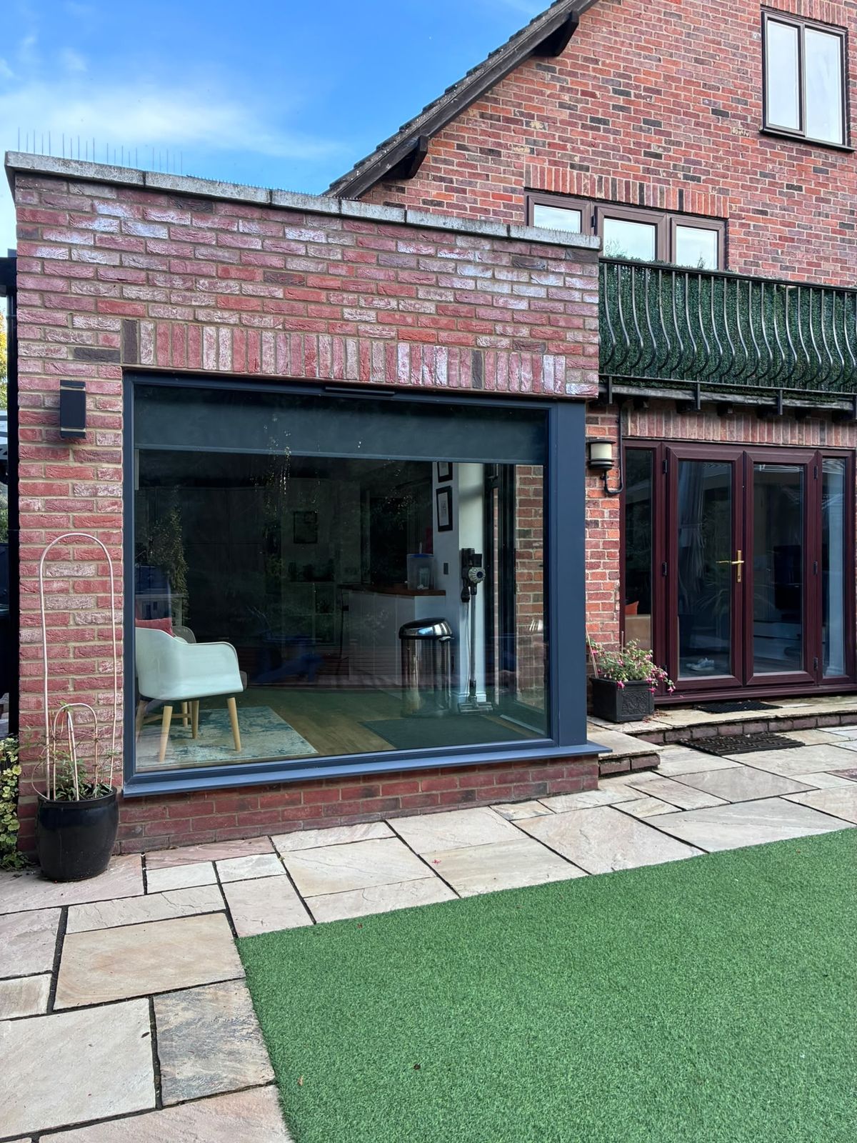 A brick extension with a full height corner window onto the patio