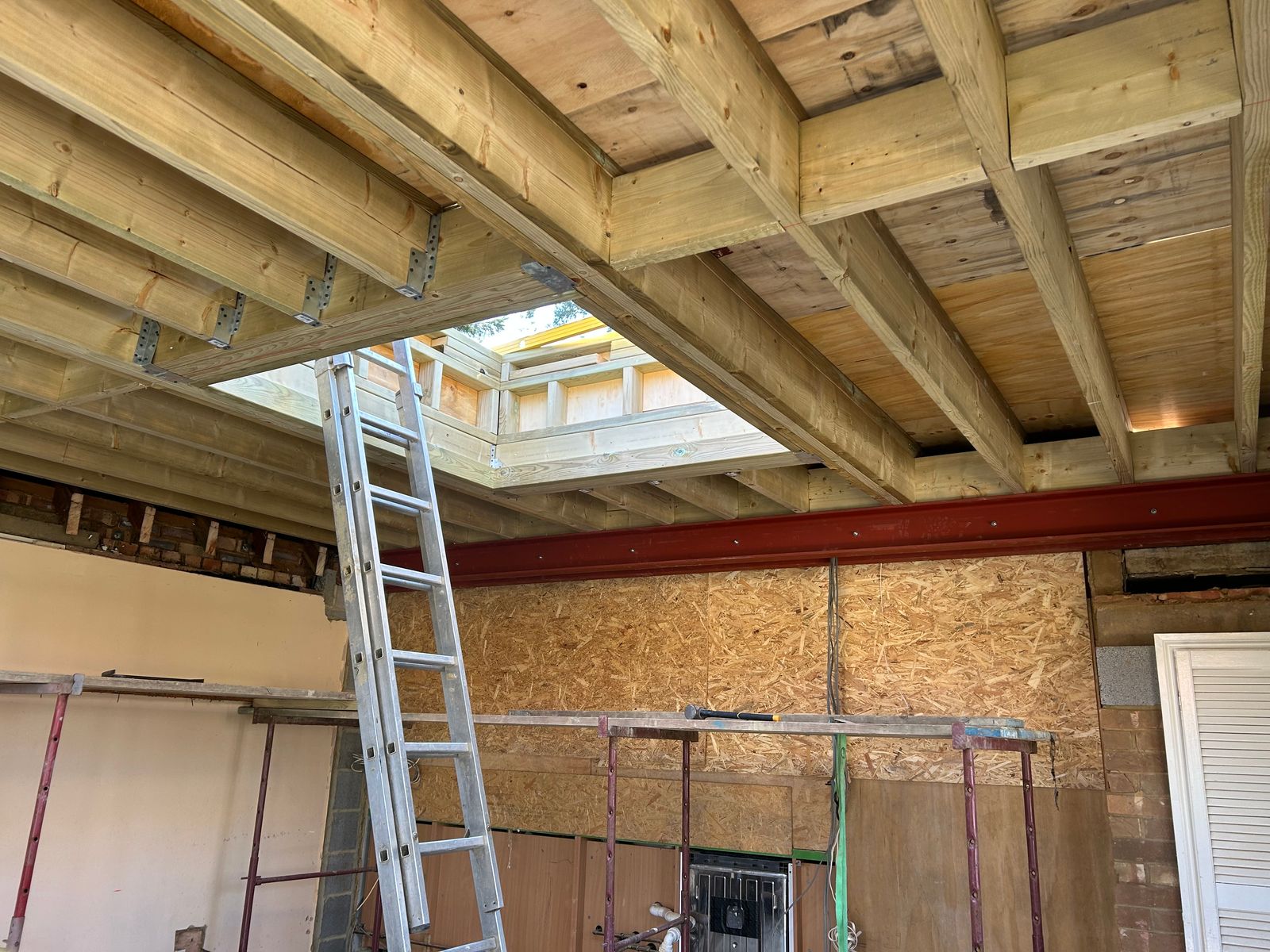 New roof joists and a steel beam inside an extension under construction