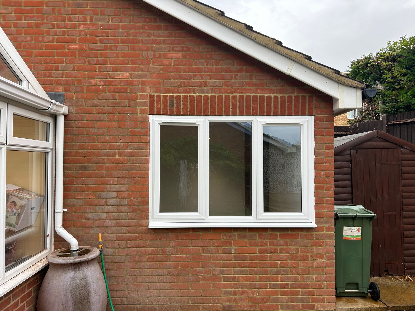 A garage door opening bricked up, with a new window fitted