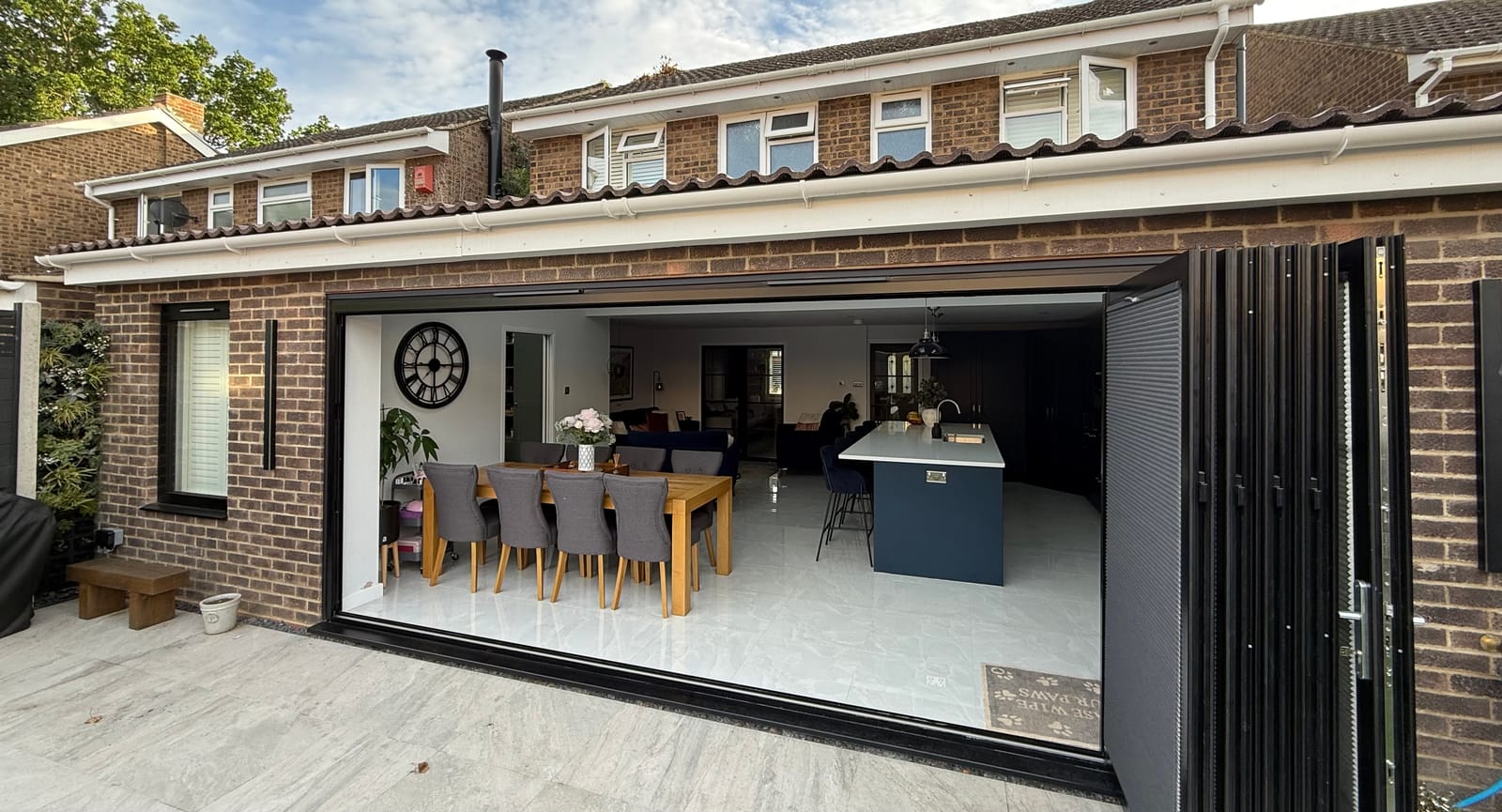 Rear extension with bi-fold doors open onto a navy kitchen and dining area