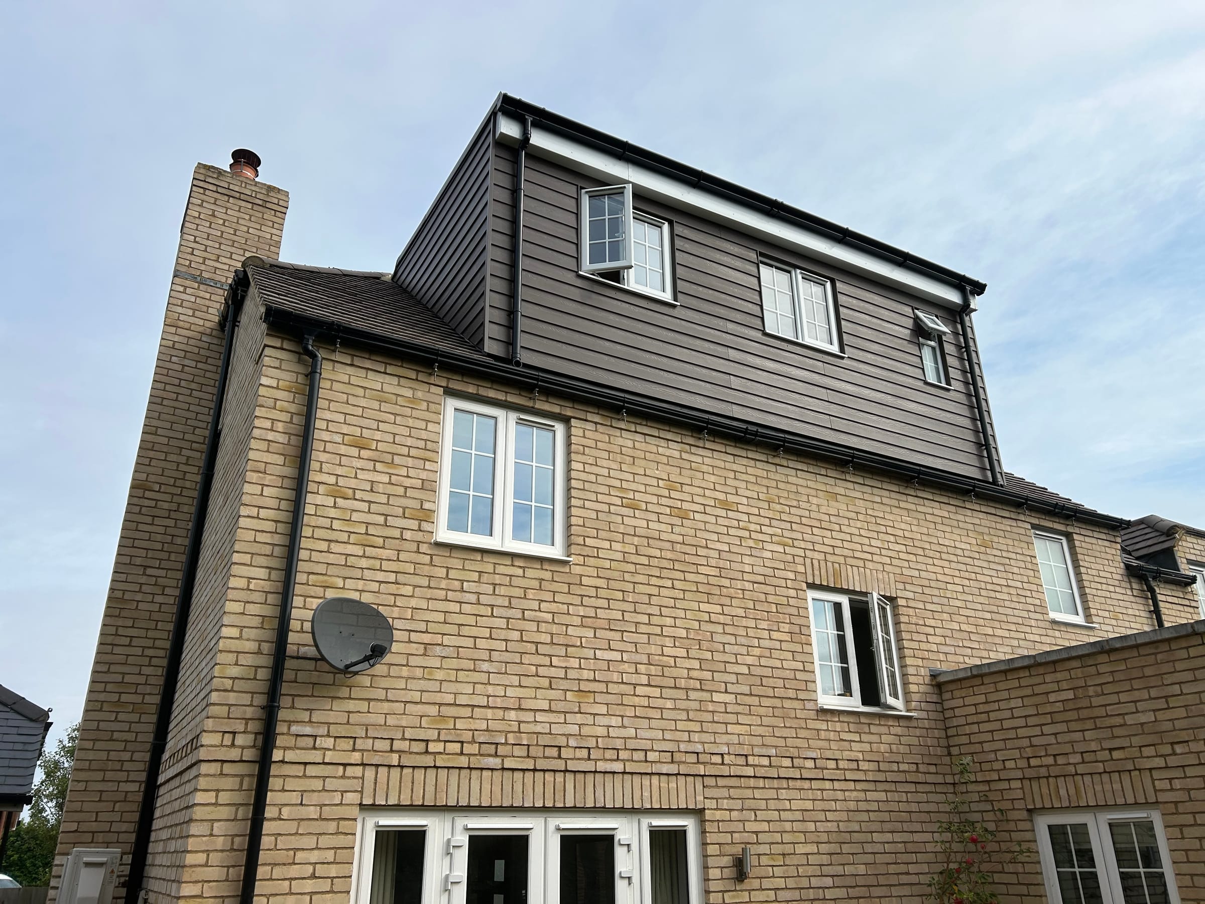 A yellow brick house with a dark clad dormer loft conversion