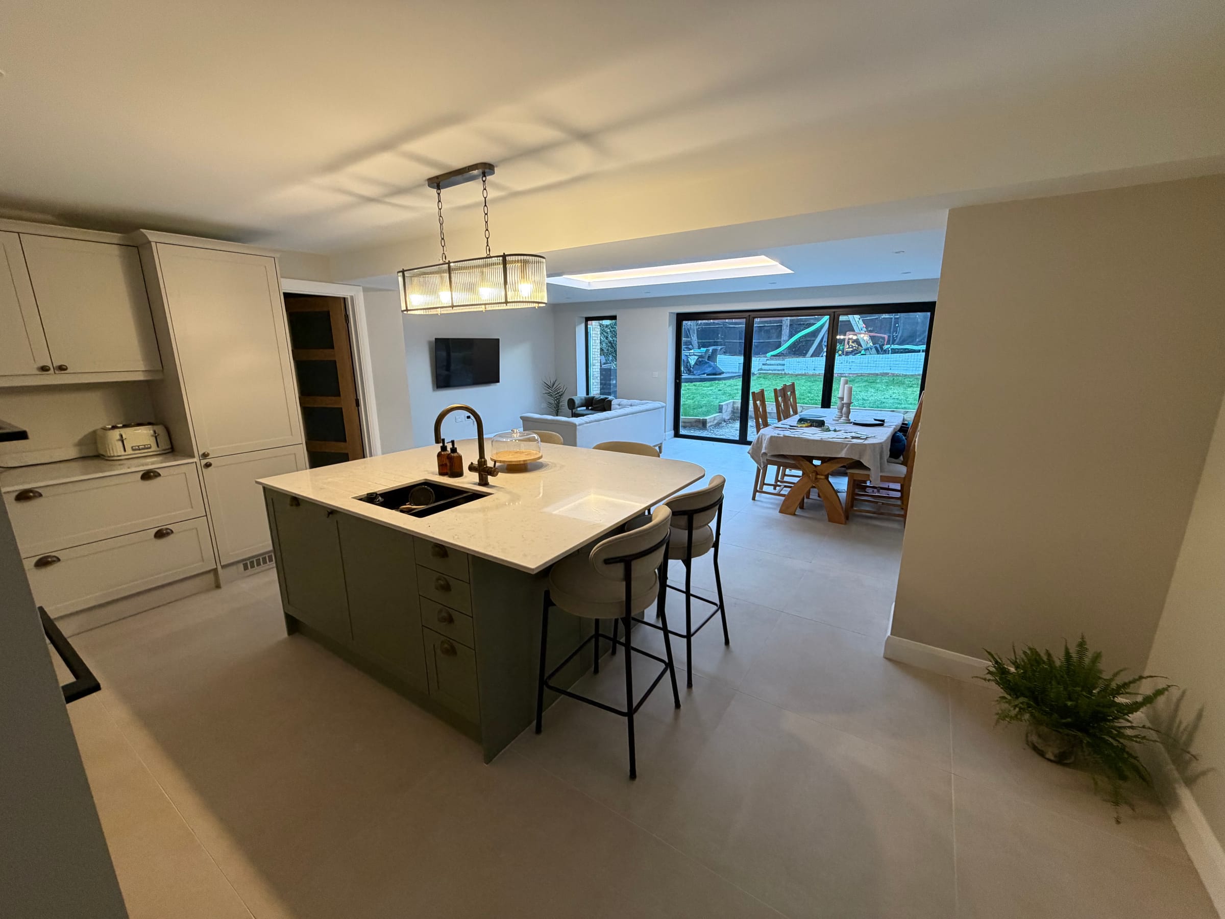 An open plan kitchen with a large island and pendant lights